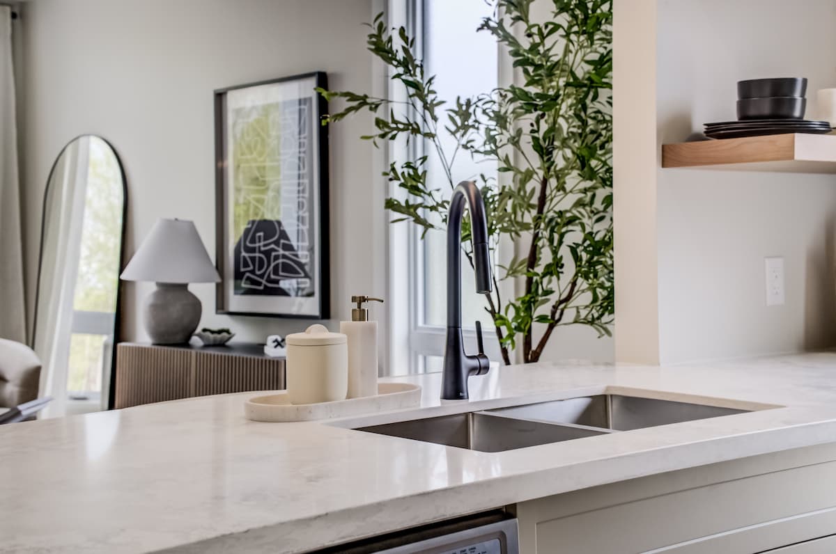 Curated material flatlay — quartz, wide-plank flooring, hardware, and textiles selected for Haravale Towns